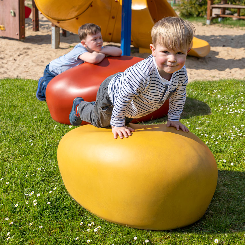 kita-pebstones-spielplatz-junge-auf-sitzstein Spielende Kinder auf Pebstones-Sitzsteinen